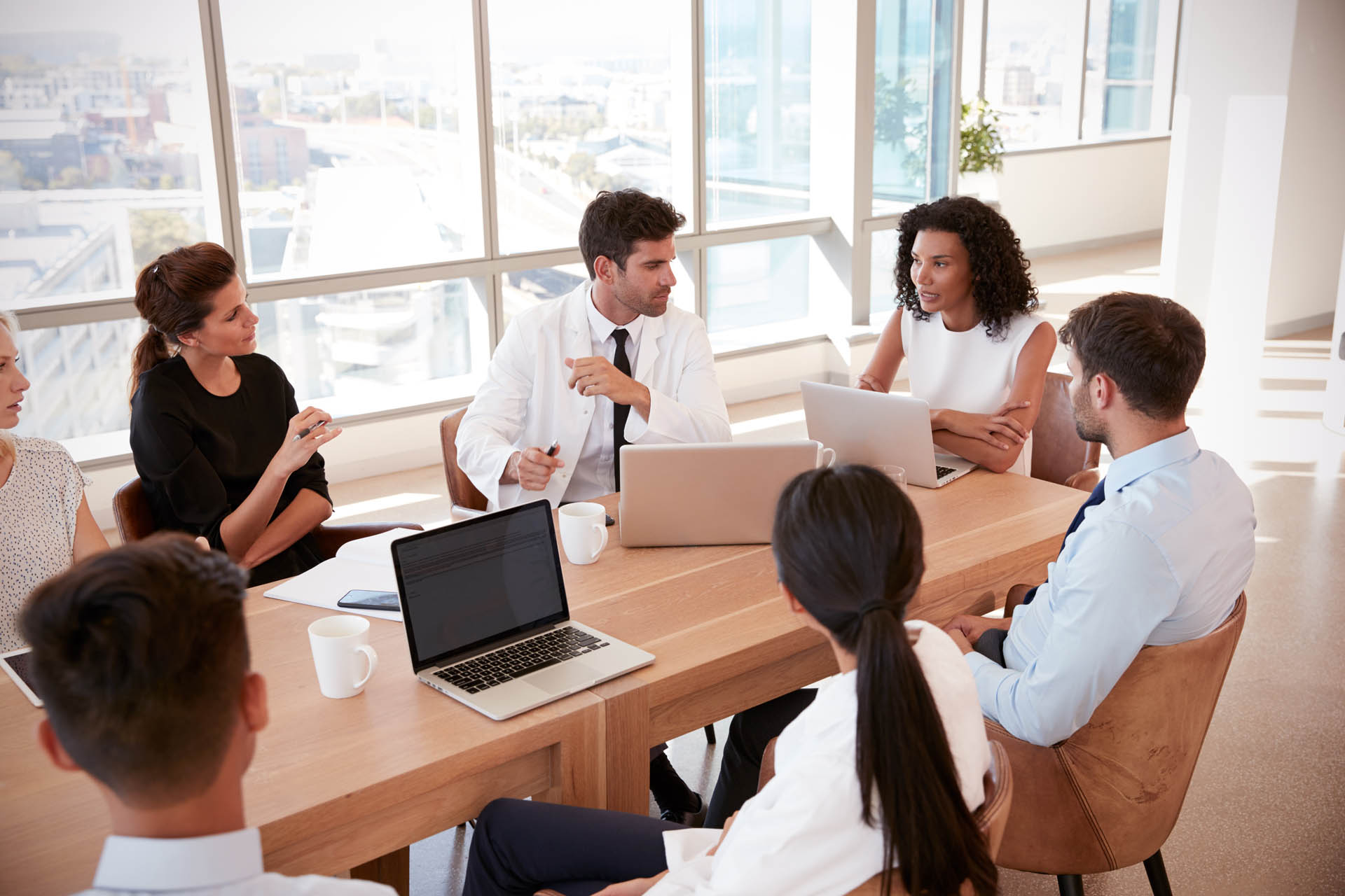 Group Of Medical Staff Meeting Around Table In Hospital